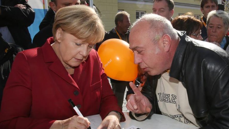 Angela Merkel signe un autographe à un supporter, le 19 septembre 2013 à Ribnitz-Damgarten