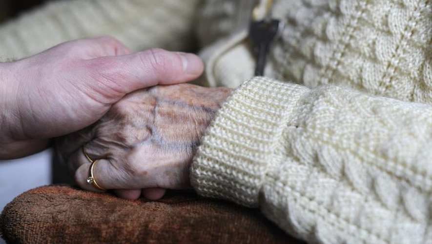 Une femme souffrant de la maladie d'Alzheimer tient la main d'un proche, le 18 mars 2011 à Angervilliers