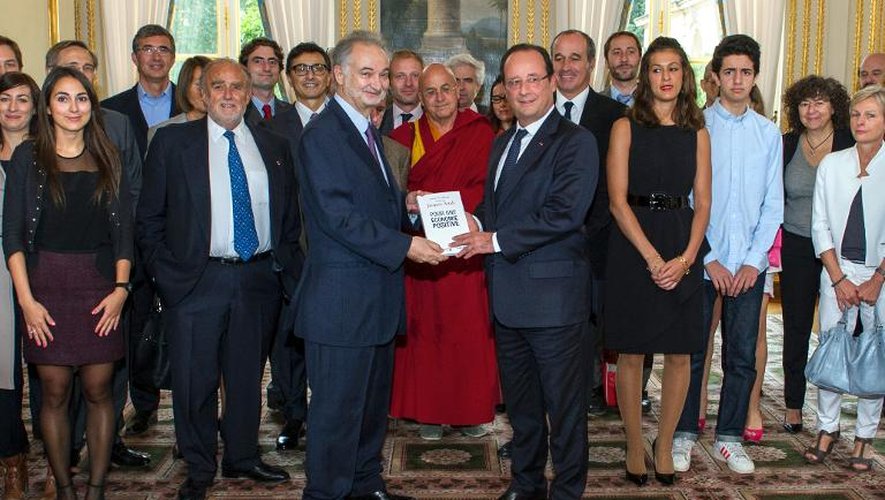 Jacques Attali (g) et François Hollande tiennent le rapport remis par l'économiste le 21 septembre 2013 à l'Elysée