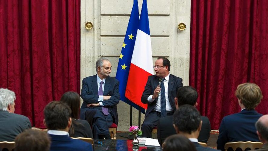 L'économiste Jacques Attali (g) écoute François Hollande après lui avoir remis son rapport sur l'"économie positive", le 21 septembre 2013 à l'Elysée