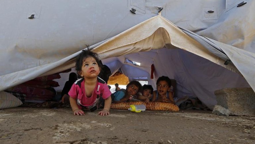 A Aski Kalak, à 40 kilomètres d'Arbil dans la zone autonome du Kurdistan irakien, des enfants dont les familles ont été déplacées tentent de se distraire sous une tente du HCR, le 17 juin 2014