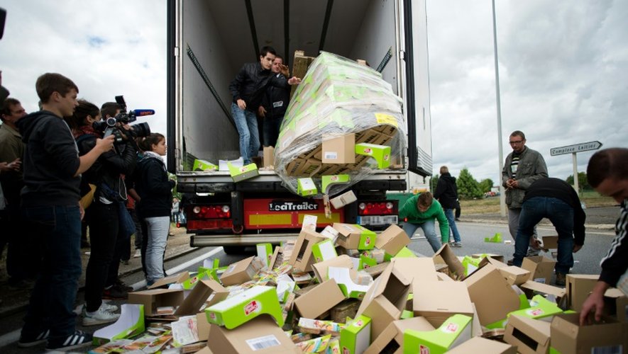 Des agriculteurs détruisent les stocks de nourriture transportés par un camion étranger, le 27 juillet 2015 à Laval, dans l'ouest de la France