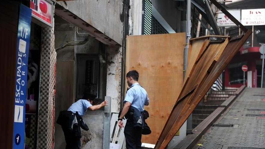 Des policiers chinois vérifient la solidité des protections après le passage du tiphon Usagi à Hong-Kong, le 23 septembre 2013