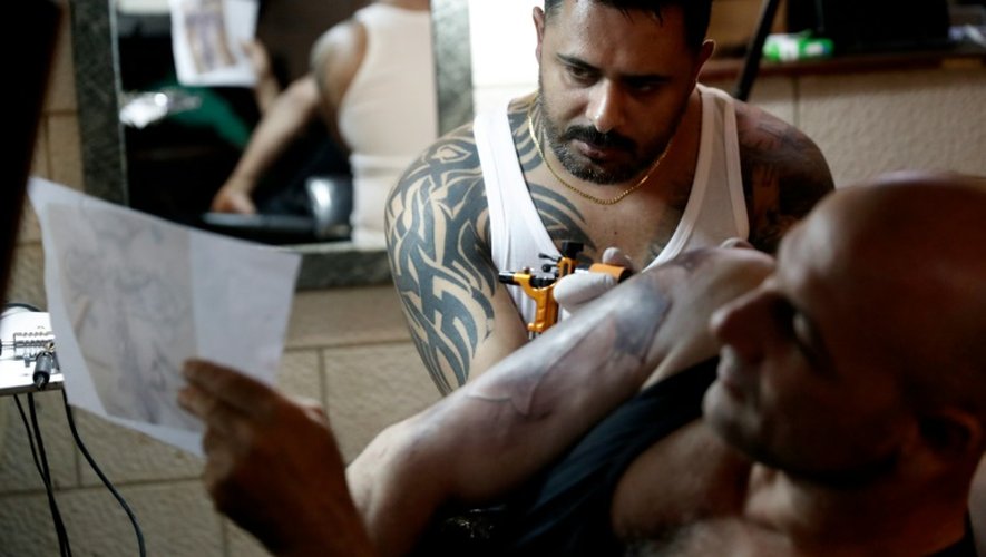 Le tatoueur Walid Ayash (d), chrétien palestinien, et un client dans son studio de Béthléem en Cisjordanie le 28 avril 2016