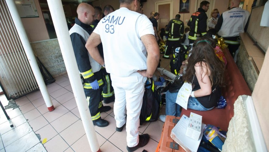 Des pompiers avec des habitants de l'immeuble où un incendie s'est déclaré le 6 juin 2016 à Saint-Denis