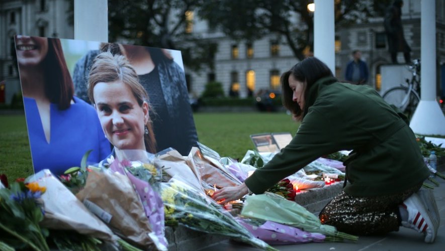 Des fleurs et bougies sont déposés devant un portrait de Jo Cox à Parliament square à Londres le 16 juin 2016