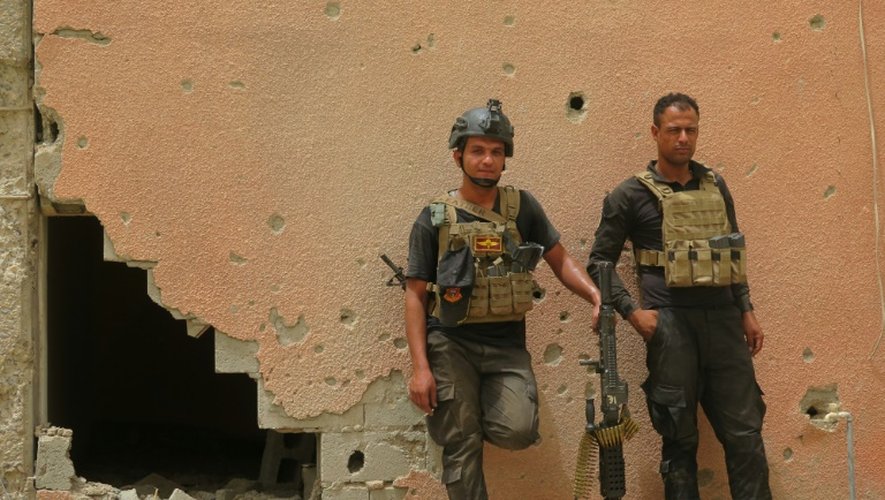 Des membres des forces antiterroristes devant un bâtiment endommagé à Fallouja lors d'une opération pour reprendre la ville au groupe EI le 16 juin 2016