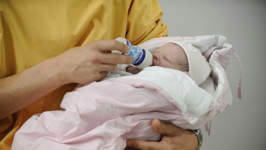 Un homme donne le biberon à son nouveau-né à la maternité d'Angers, le 25 octobre 2013