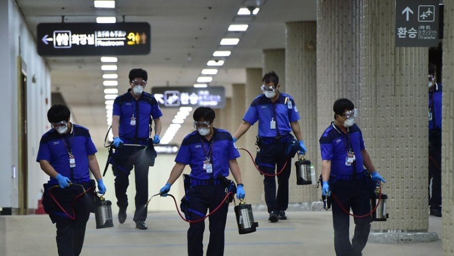 Des employés de l'aéroport de Séoul désinfectent les locaux, le 17 juin 2015 pour lutter contre une épidémie de Coronavirus Mers