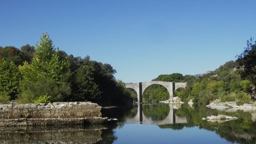 Les trois arches du pont de Saint-Etienne d’Issensac se reflètent dans l’eau.