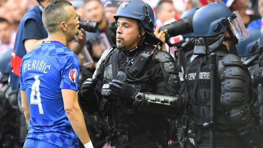 Le joueur croate Ivan Perisic face aux forces de l'ordre après les jets de fumigènes par des supporters de son pays sur la pelouse lors du match de l'Euro-2016 contre la République Tchèque à Saint-Etienne, le 17 juin 2016