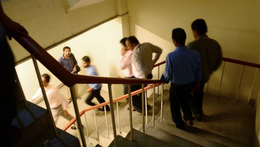 Des employés quittent leur lieu de travail alors que la terre à tremblé à Karachi au Pakistan, le 24 septembre 2013