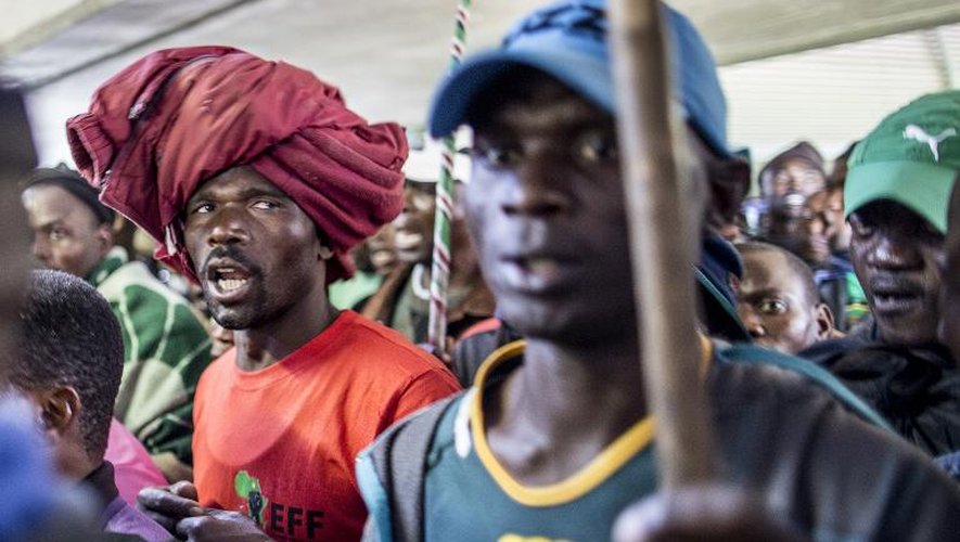 Des mineurs écoutent le leader syndical à l'origine de la grève des mines de platine, Joseph Mathunjwa, qui annonce la fin du mouvement le 23 juin 2014, à Rustenburg, à 200 km au nord-ouest de Johannesburg