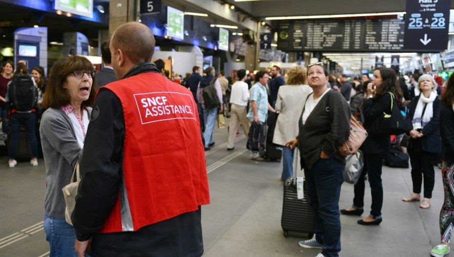 Un employé de la SNCF aide les voyageurs, lors d'une grève à la gare Montparnasse le 20 juin 2014