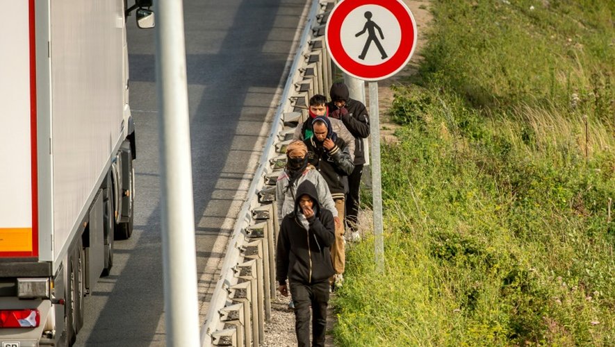 Des migrants marchent le long d'une route menant vers le tunnel sous la Manche, le 29 juillet 2015 à Coquelles