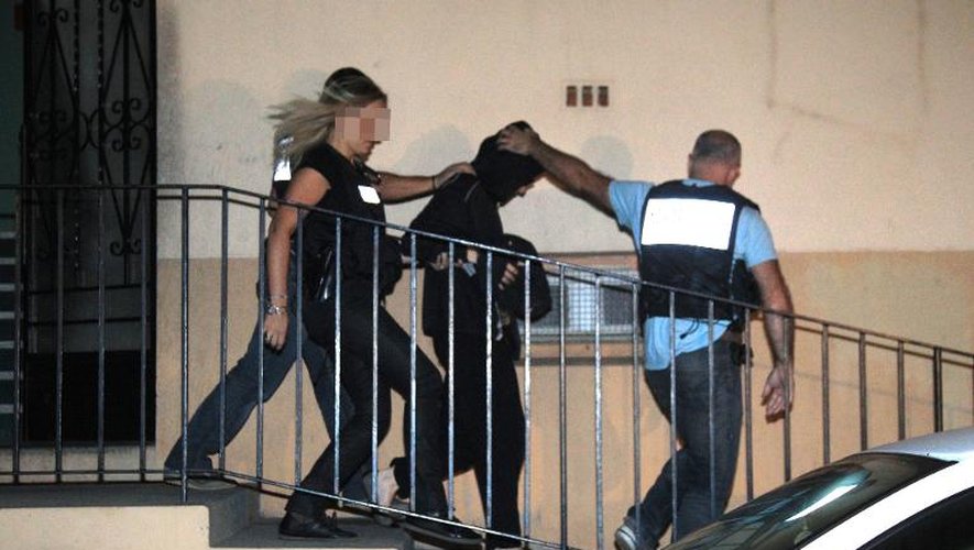 Cecile Bourgeon (C), placée en détention  provisoire, est escortée par des policiers le 25 septembre 2013 à Perpignan