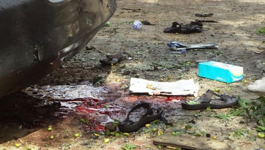 Des sandales tâchées de sang sur le lieu d'un attentat à la bombe à Kano le 23 juin 2014