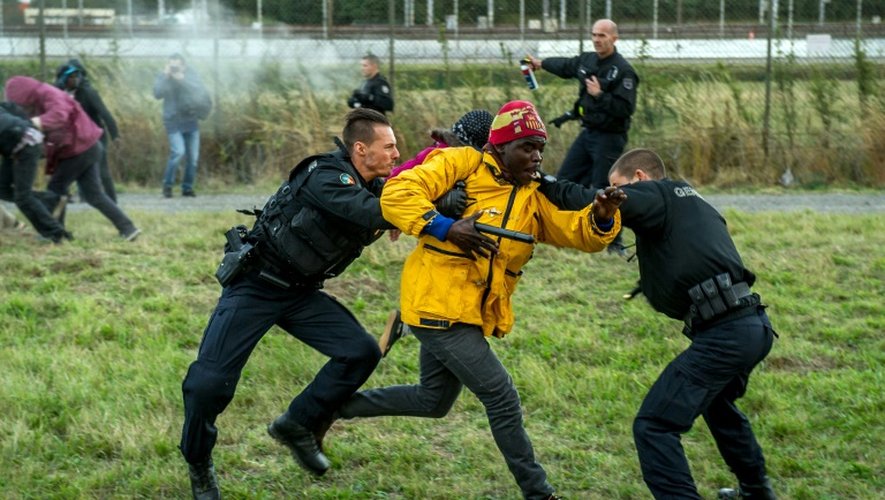 Des gendarmes tentent de stopper un migrant le 29 juillet 2015 à Coquelles