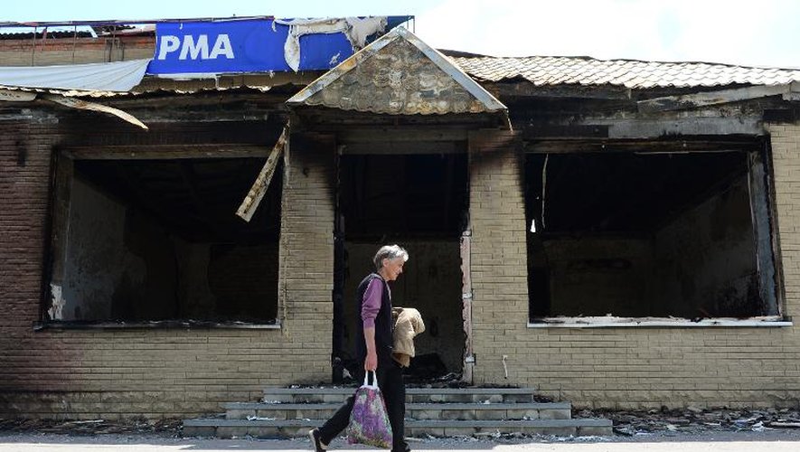 Un habitant resté à Slaviansk passe devant une maison incendiée, le 24 juin 2014