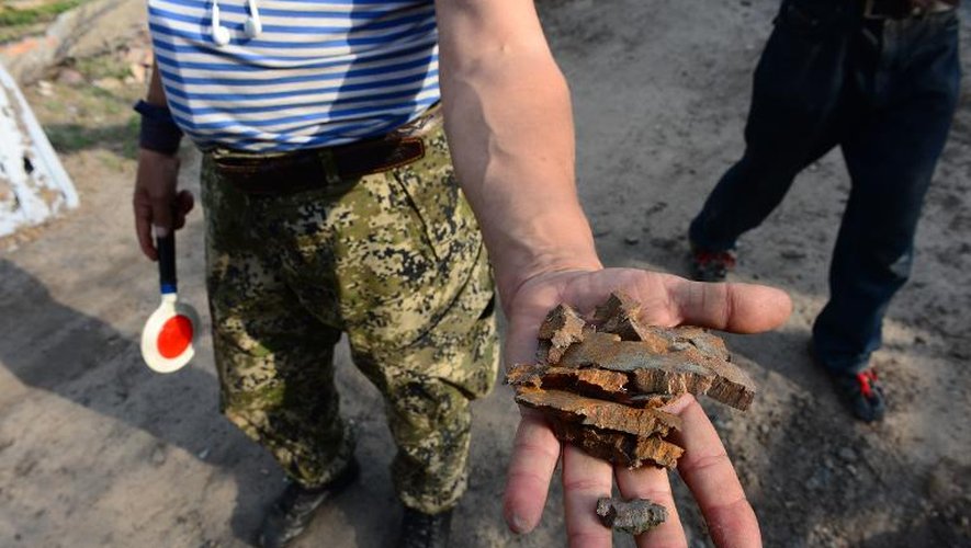 Un séparatiste russe montre des éclats de shrapnel après un bombardement à Slaviansk, le 24 juin 2014