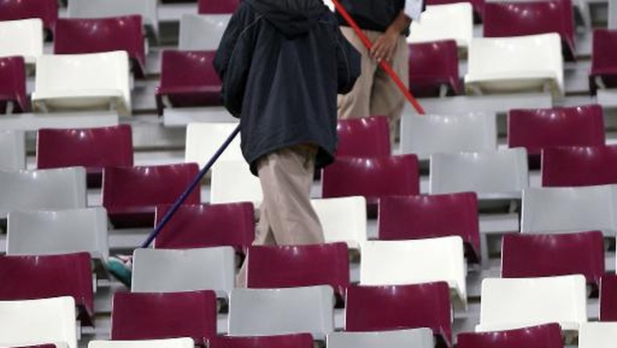 Des travailleurs asiatiques nettoient le stade après la demi-finale Australie-Ouzbékistan de la Coupe d'Asie 2011, le 25 janvier 2011 à Doha (Qatar)