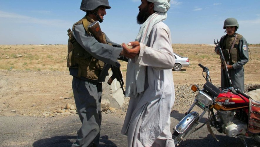 Un policier afghan fouille un voyageur à un point de contrôle à Lashkar Gah, la capitale de la province de Helmand, le 30 juillet 2015