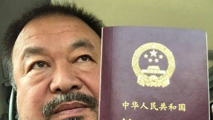 L'artiste chinois Ai Weiwei, le 22 juillet 2015 à Pékin pose avec son passeport qui vient de lui être rendu