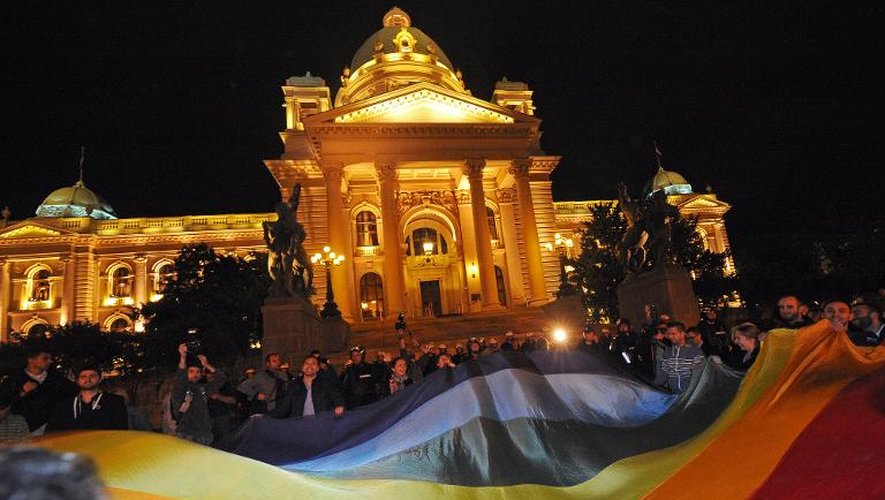 Des militants des droits des homosexuels tiennent une bannière arc-en-ciel, symbole de leur mouvement, devant le Parlement serbe le 27 septembre 2013 à Belgrade
