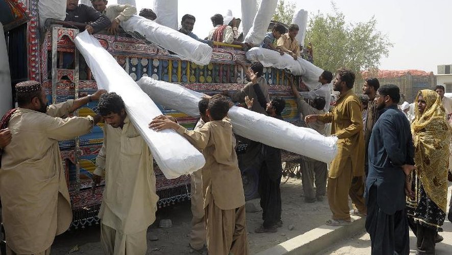 Des Pakistanais récupèrent des tentes pour se mettre à l'abri après le tremblement de terre le 28 septembre 2013 dans la région d'Awaran