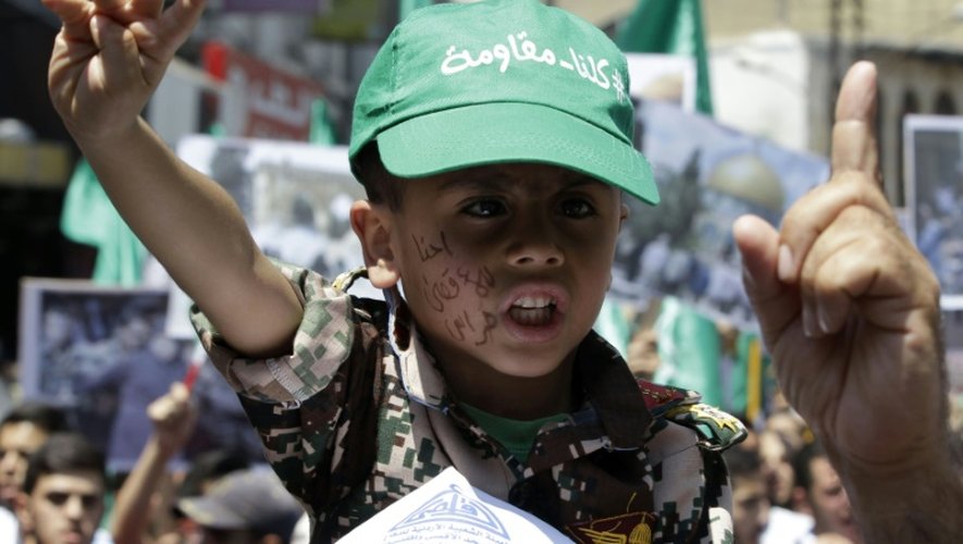 Un garçon portant une casquette où est inscrit en arabe "Nous sommes tous des résistants" participe à une manifestation contre les violations israéliennes, le 31 juillet 2015 à Jérusalem