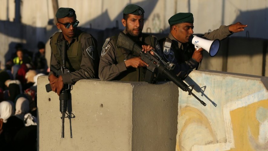 Des soldats israéliens surveillent des Palestiniens qui passent par le checkpoint de Qalandia, le 17 juin 2016
