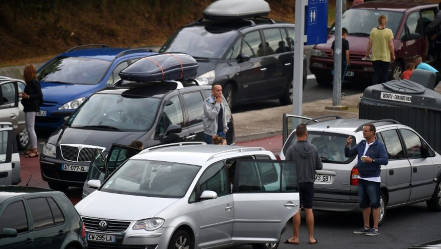 Des voyageurs font une pause sur une aire de repos de l'A7 près du péage de Vienne, en Isère, le 1er août 2015