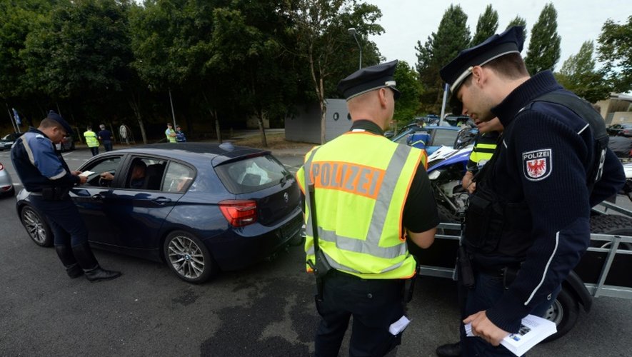 Une équipe intégrant un policier français (g), un néerlandais (c) et un allemand (d) contrôle des voitures sur l'A10 à Virsac, en Gironde, le 1er août 2014