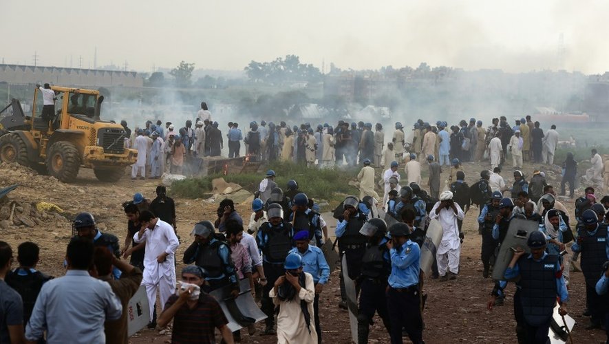 Un bulldozer en action le 30 juillet 2015 sous le regard impuissant des habitants expulsés du "Afghan Basti" ou "ghetto afghan", un vaste bidonville d'Islamabad, la capitale du Pakistan