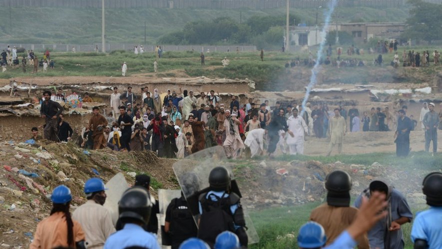 Les habitants du "ghetto afghan" d'Islamabad lancent des pierres aux policiers pakistanais, qui répliquent avec des gaz lacrymogènes, le 30 juillet 2015 pendant la démolition du bidonville
