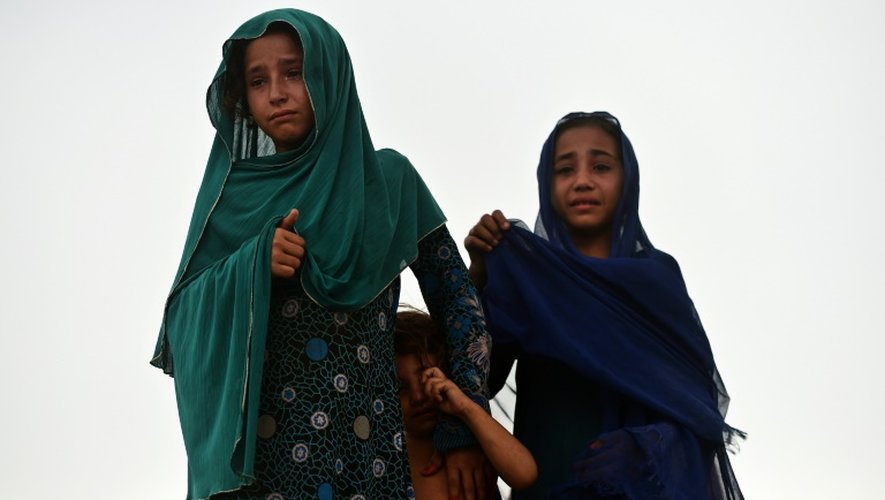 Deux jeunes habitantes du "ghetto afghan" d'Islamabad pleurent pendant l'opération de démolition du bidonville, le 30 juillet 2015