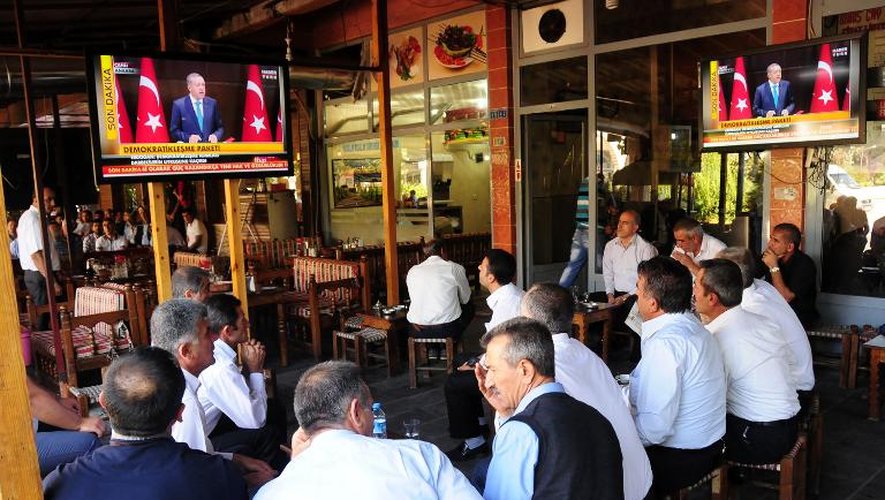 Des Kurdes écoutent le Premier ministre turc Recep Tayyip Erdogan à la télévision, le 30 septembre 2013 à Diyarbakir