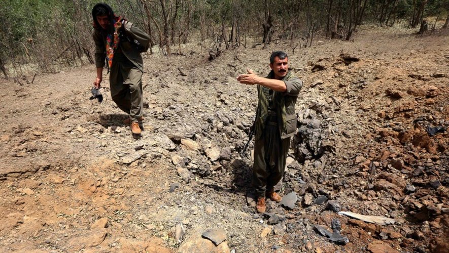 Des membres du PKK inspectent un cratère qui aurait été causé par un raid aérien turc le 29 juillet 2015 sur la montagne de Qandil, au nord de l'Irak