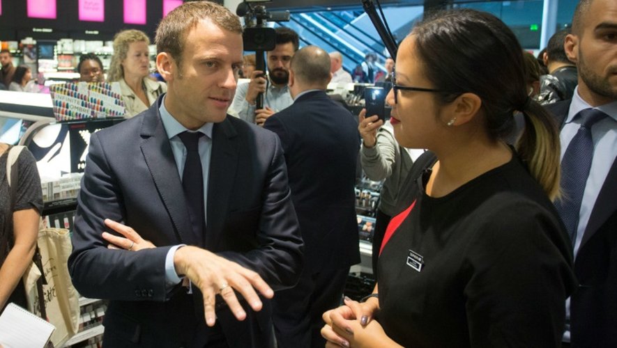 Le ministre de l'Economie Emmanuel Macron s'entretient avec une salariée, lors d'une visite de commerces du quartier Saint- Lazare à Paris, le 22 juin 2016