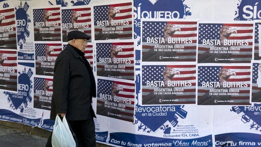 Un homme passe à côté d'affiches dénonçant les "fonds vautours" le 18 juin 2014 à Buenos Aires