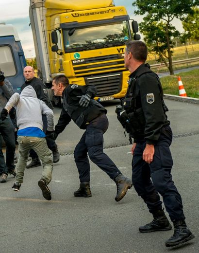 Un migrant tente d'échapper aux forces de police à Coquelles près de Calais, le 30 juillet 2015