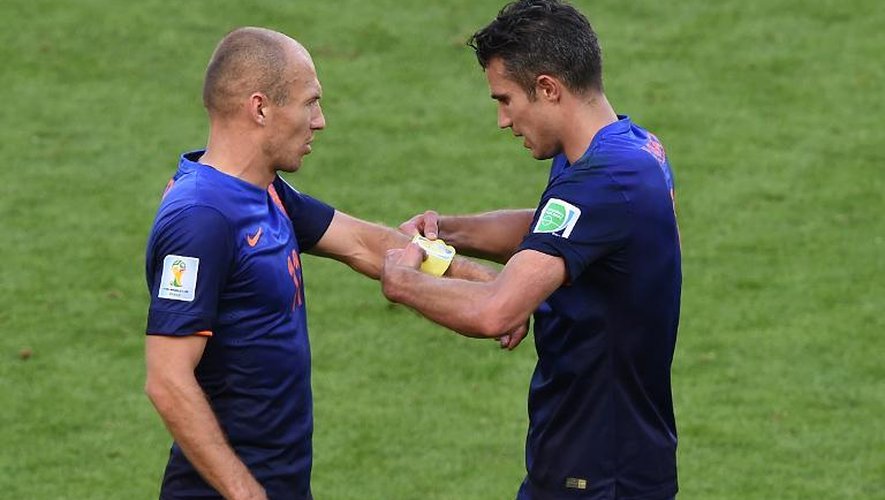 Les attaquants néerlandais Arjen Robben (g) et Robin van Persie (d) s'échangent le brassard de capitaine lors du match Pays-Bas - Australie, le 18 juin 2014 au stade Beira-Rio à Porto Alegre