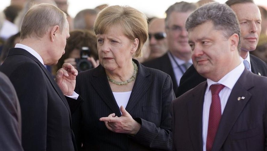La chancelière allemande Angela Merkel s'entretient avec le président russe Vladimir Poutine (g) et le président élu ukrainien Petro Poroshenko (d) à Ouistreham en Normandie lors des commémorations du 70e anniversaire du Jour J, le 6 juin 2014