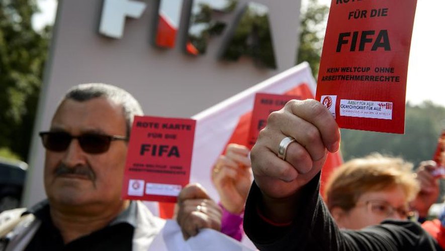 Des membres de l'Internationale des travailleurs du bâtiment et du bois (IBB) et du syndicat Unia  brandissent des cartons rouges contre le Qatar, devant le siège de la Fifa, le 3 octobre 2013 à Zürich