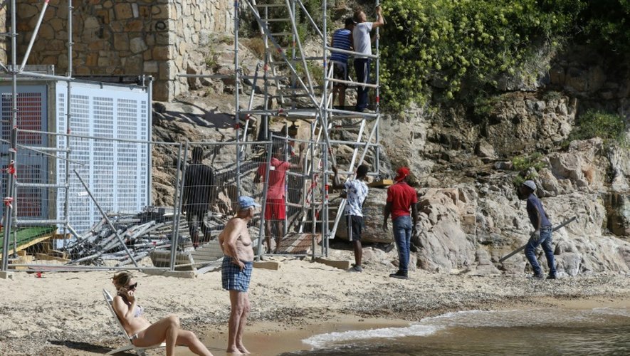 Des ouvriers démontent un ascenseur sur une plage de Vallauris, près de la villa du roi d'Arabie saoudite, sous les yeux de baigneurs, le 3 août 2015