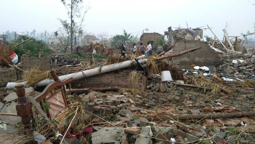 Des habitants de Yancheng, dans la province de Jiangsu à l'est de la Chine marchent dans les ruines des maisons détruites par des pluies torrentielles, de la grêle et des tornades, le 23 juin 2016