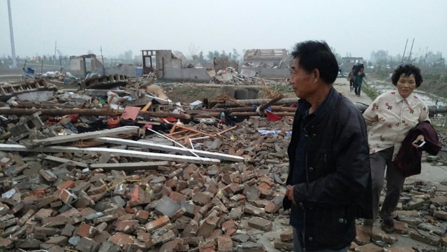 Des habitants de Yancheng, dans la province de Jiangsu à l'est de la Chine marchent dans les ruines des maisons détruites par des pluies torrentielles, de la grêle et des tornades, le 23 juin 2016