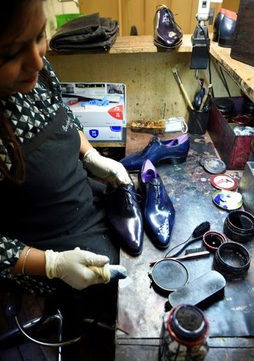 Une employée apporte la touche finale à une paire de chaussures dans l'atelier Berluti à Paris, le 3 mai 2016