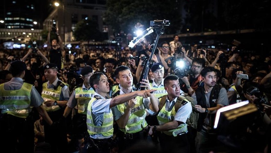 A Hong Kong, des policiers le long de la manifestation pro-démocratie, le 2 juillet 2014
