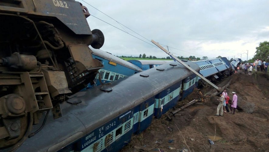 Des fonctionnaires observent les deux trains, dont l'un a fini sur le toit de l'autre, qui ont déraillé le 5 février 2015 près de la ville d'Harda dans l'état indien de Madhya Pradesh